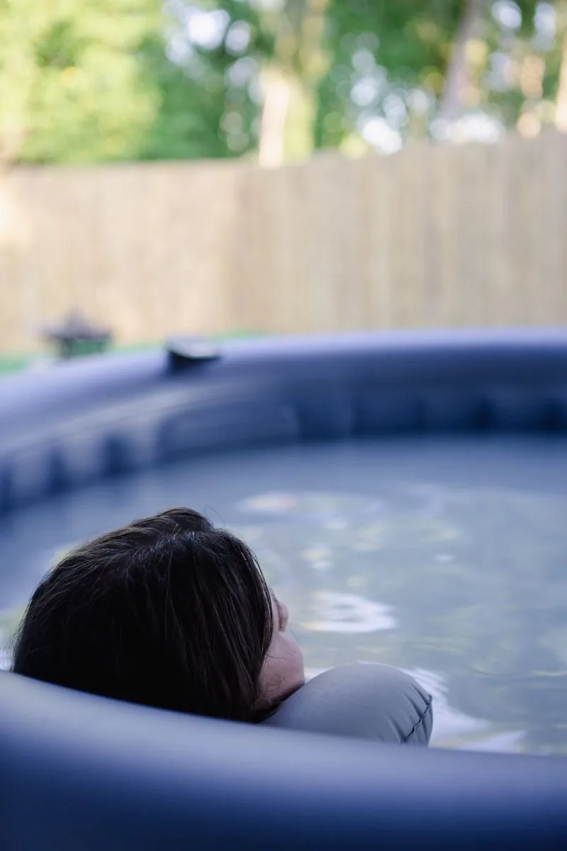 Gast ruht bis zum Hals im milchigen Wasser eines Pools