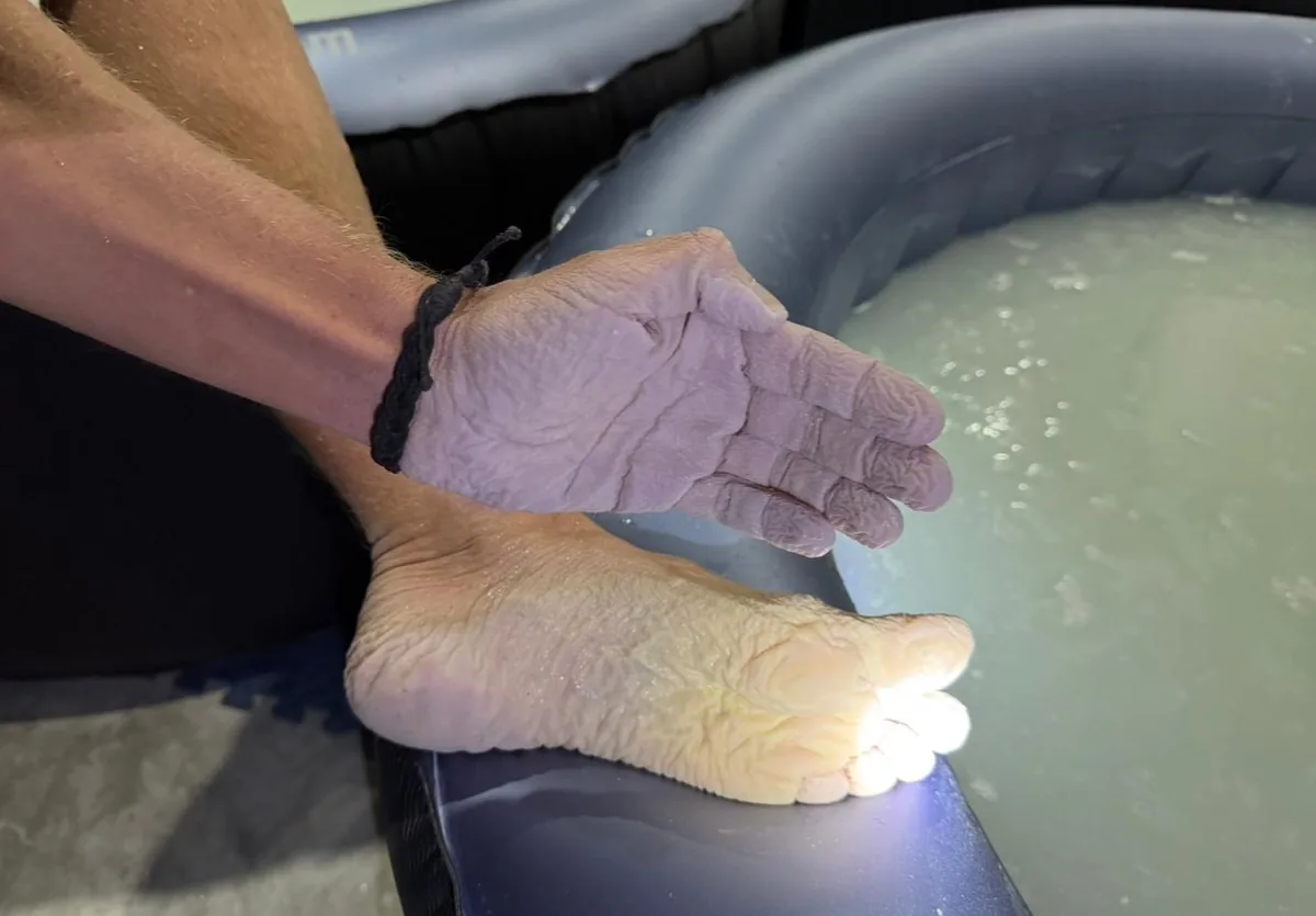 Ein Fuß taucht aus dem milchigen Carbonatwasser auf